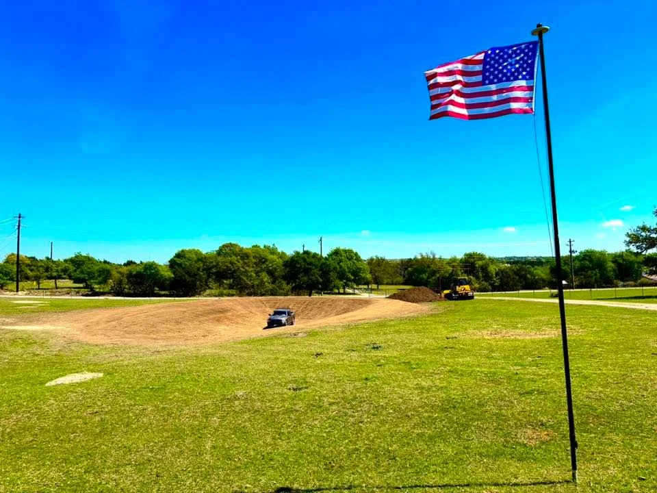 Excavated site with graded earth, heavy equipment, and cleared land preparation